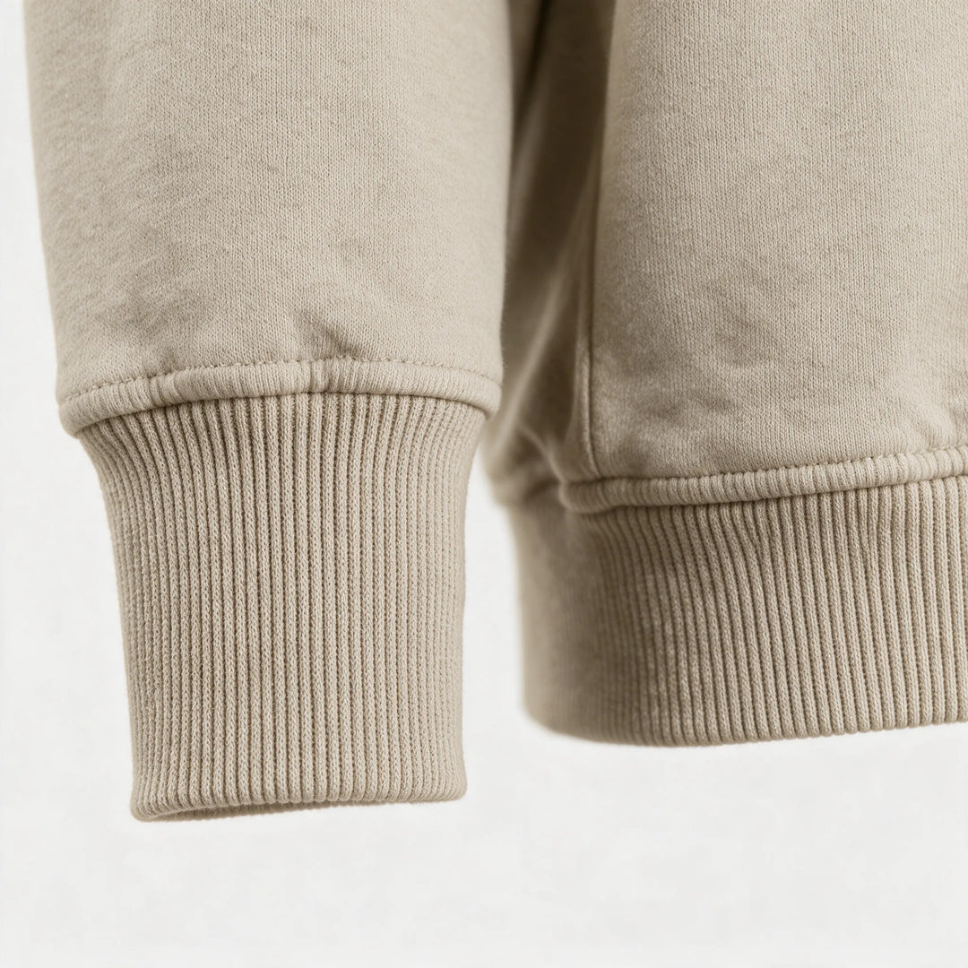 Close-up of the ribbed cuff and hem of the beige sweatshirt