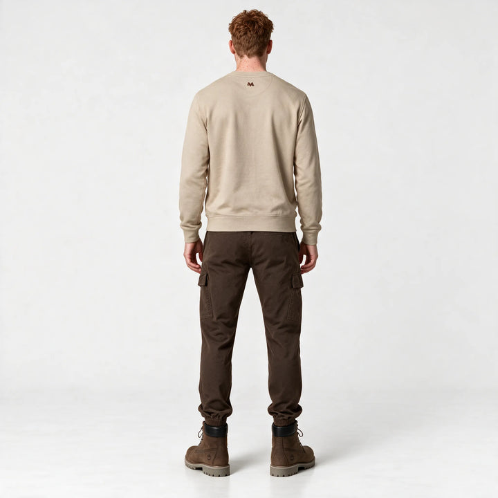 Full-length back view of the beige sweatshirt styled with brown cargo pants