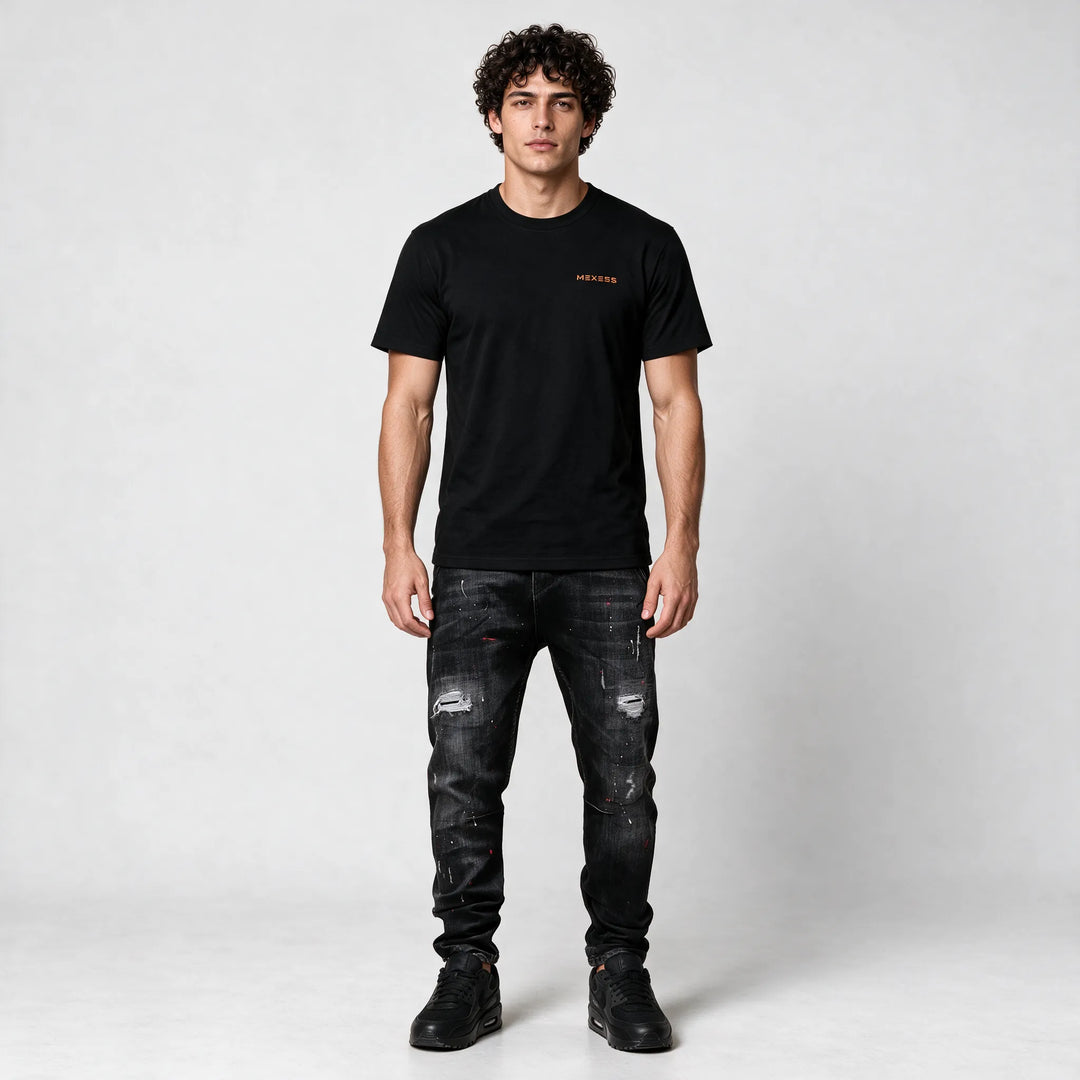 Full-length front view of the black t-shirt styled with ripped black jeans