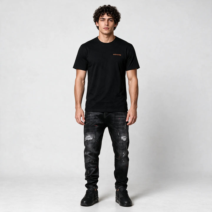Full-length front view of the black t-shirt styled with ripped black jeans