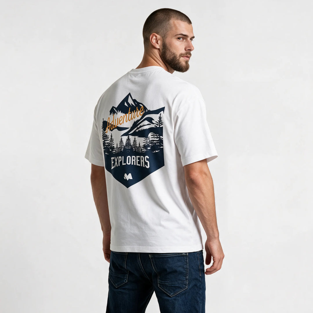 Men's mountain graphic tee in white, side-back view with a navy mountain badge and EXPLORERS lettering