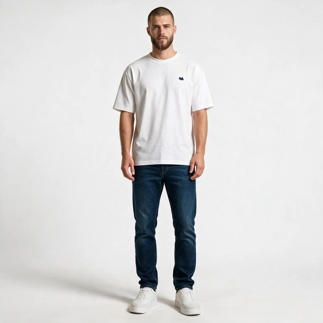 Full-length front view of the white t-shirt in a regular fit with dark jeans