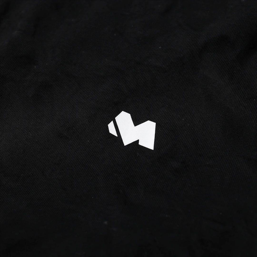 Close-up of the white M logo print on the chest of the black t-shirt