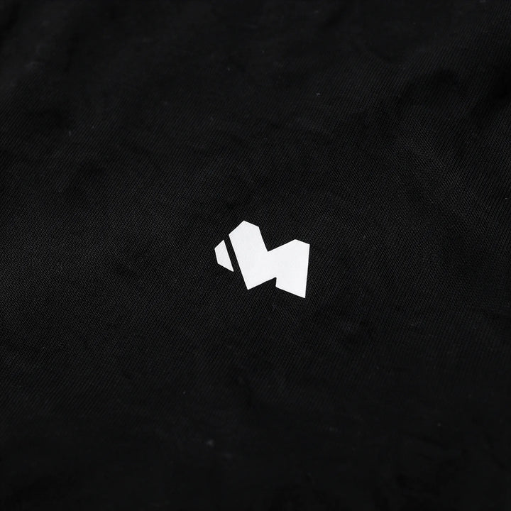 Close-up of the white M logo print on the chest of the black t-shirt