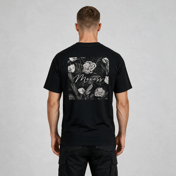 Back view of the black t-shirt with a framed black-and-white floral print and MEXESS script