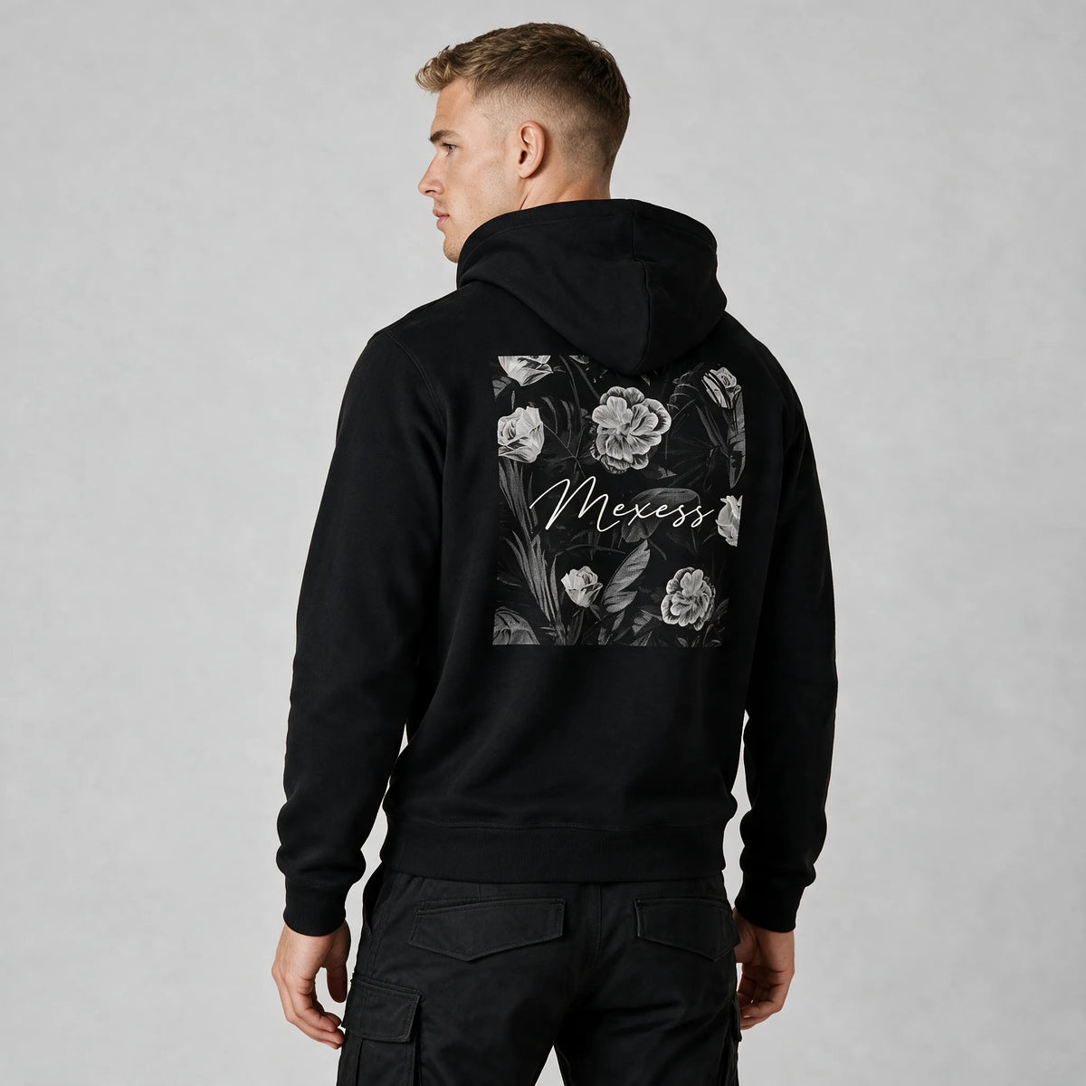 Black floral hoodie for men, back view with a monochrome rose and leaf print and white Mexess script