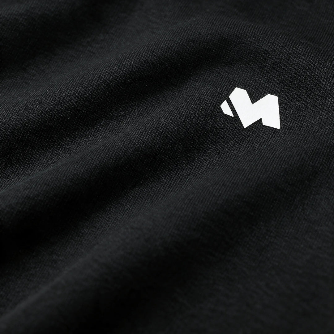 Close-up of the white M logo printed on the black brushed fabric of the hoodie chest