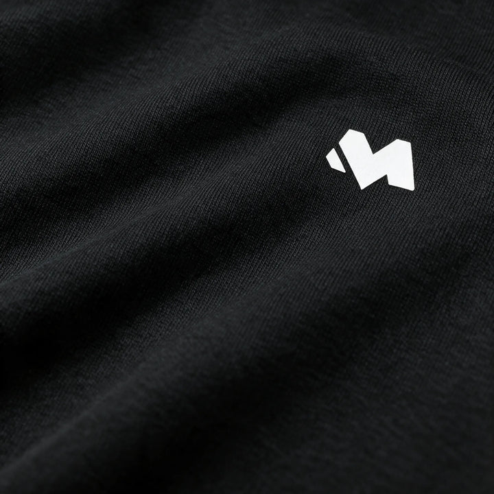 Close-up of the white M logo printed on the black brushed fabric of the hoodie chest