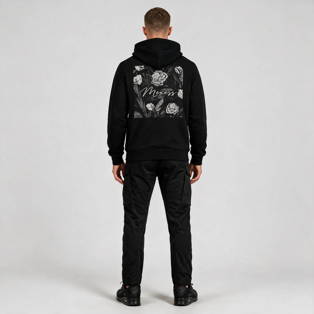 Back print hoodie in black, full-length rear view of the floral square print with black cargo pants