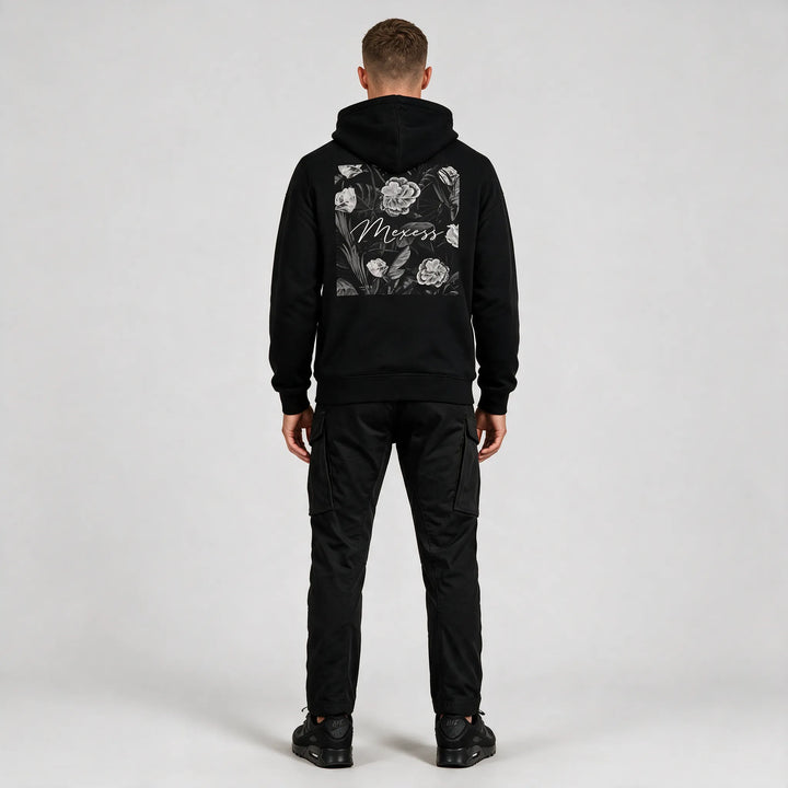 Back print hoodie in black, full-length rear view of the floral square print with black cargo pants