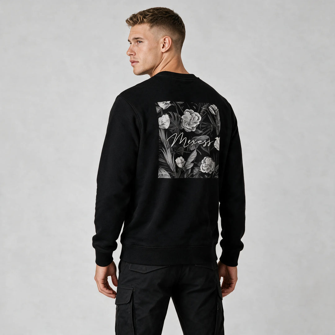 Back view of the black sweatshirt with a framed black-and-white floral print and MEXESS script