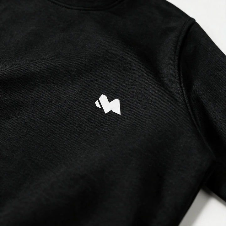 Close-up of the white M logo print on the left chest of the black sweatshirt