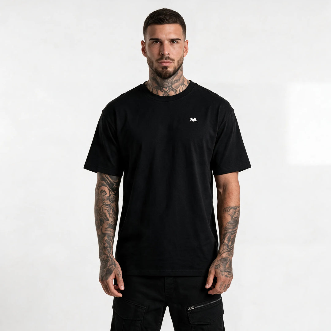 Model in a black organic cotton t-shirt with a small white MEXESS logo on the left chest, front view