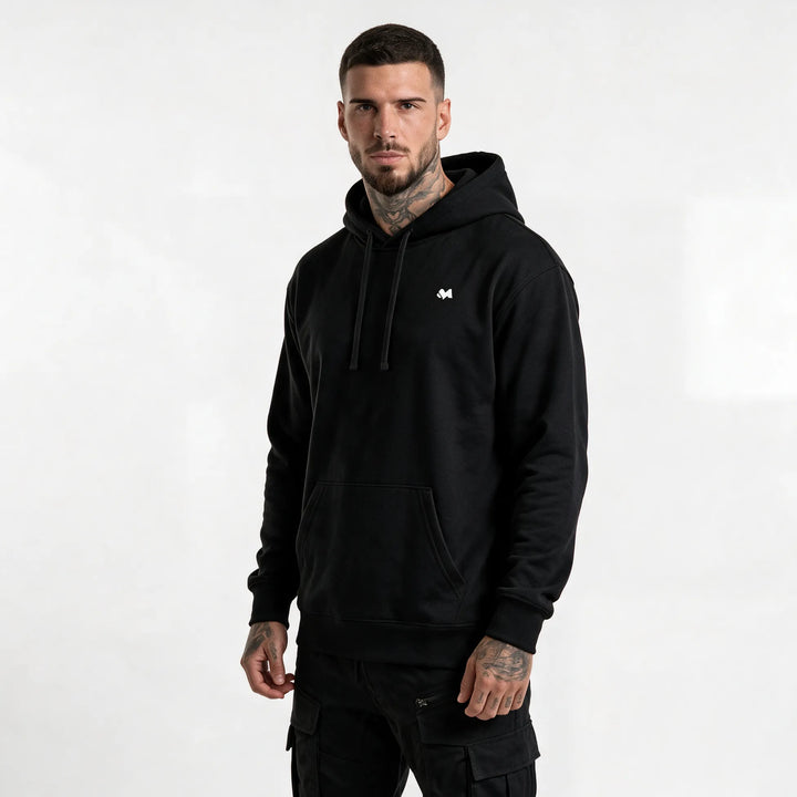 Model in a black organic cotton hoodie with a small white MEXESS logo on the left chest, front view