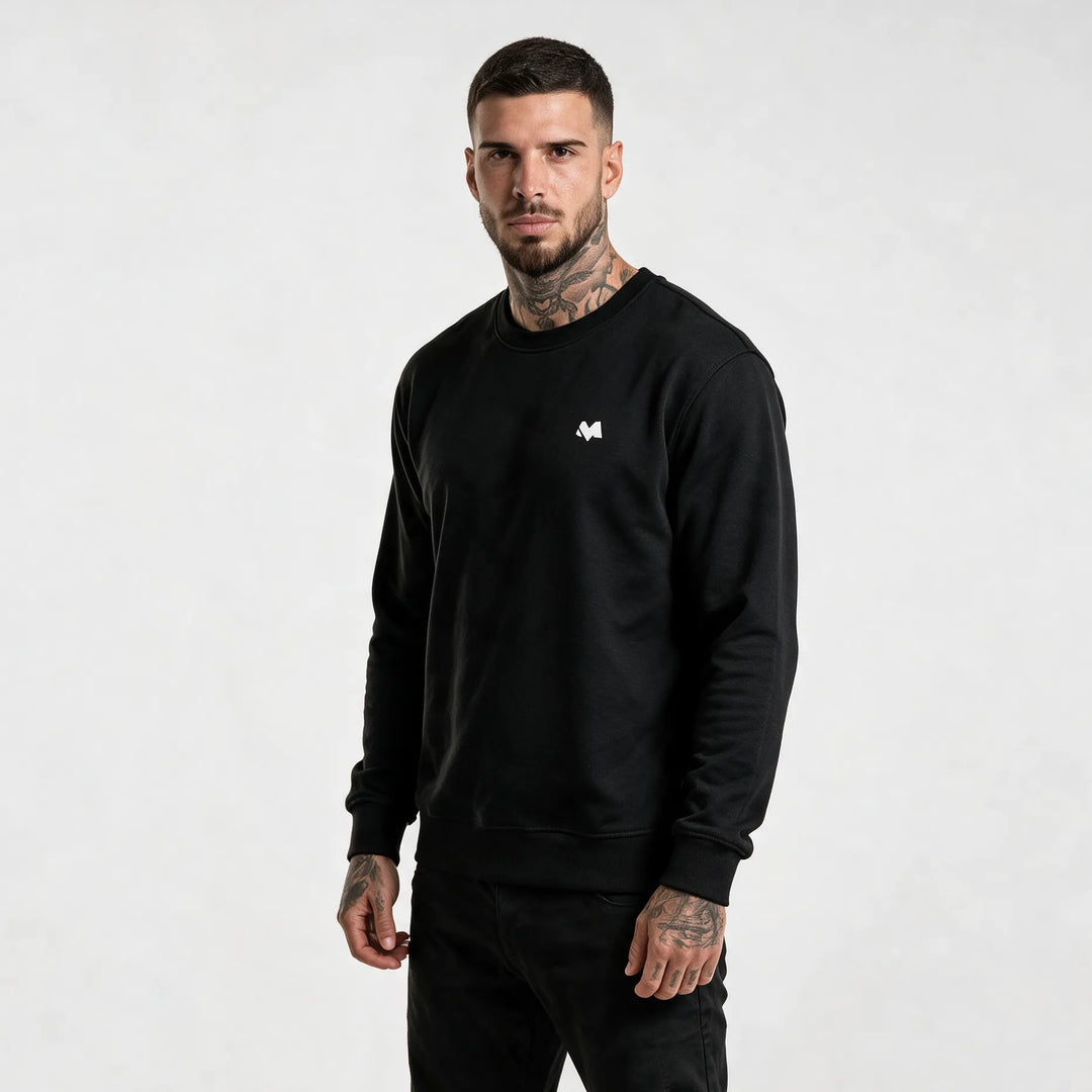 Model in a black organic cotton sweatshirt with a small white MEXESS logo on the left chest, front view