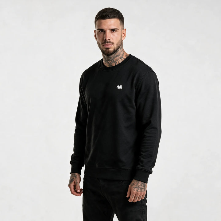Model in a black organic cotton sweatshirt with a small white MEXESS logo on the left chest, front view