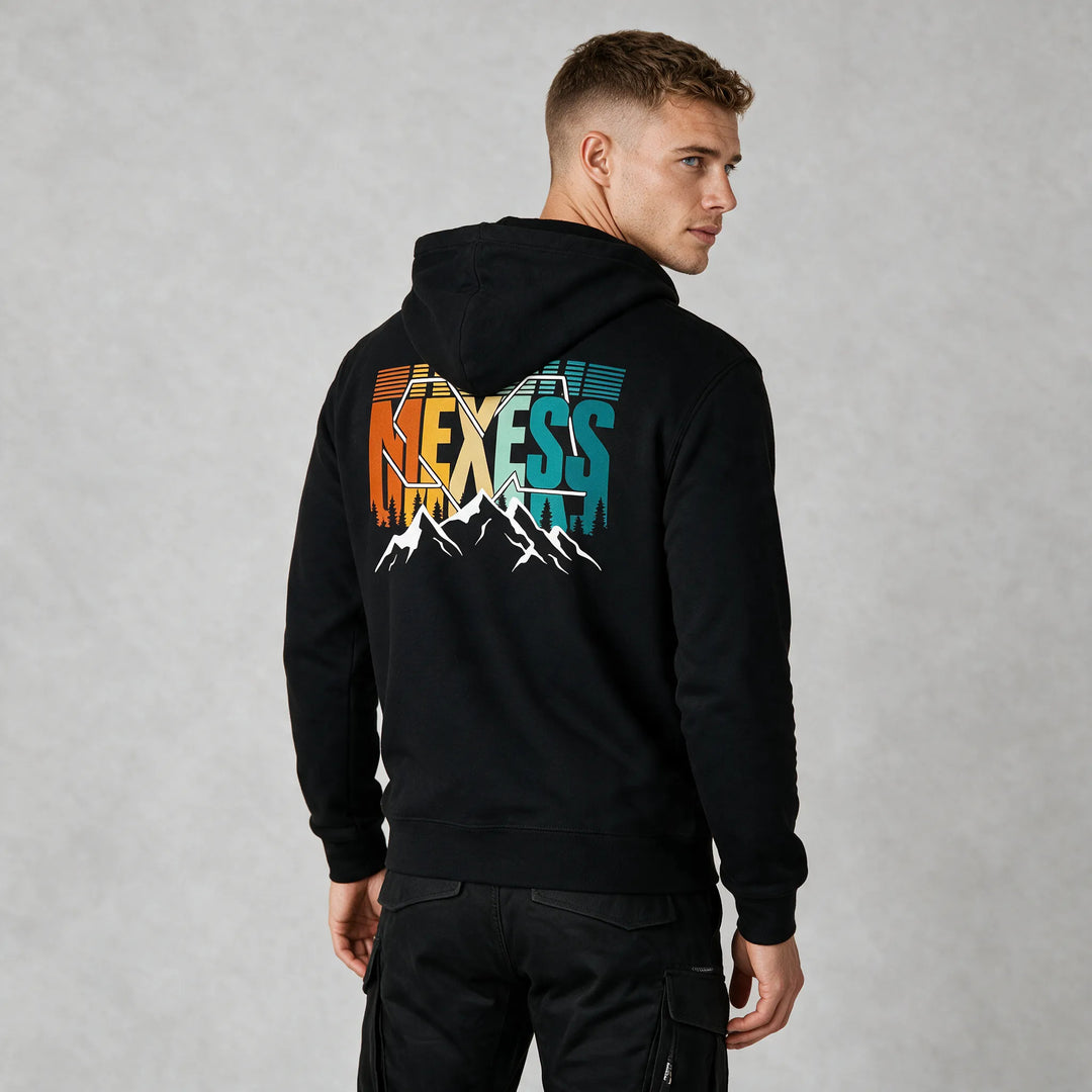 Black organic cotton hoodie with a colorful retro MEXESS mountain and pine tree back print, rear three-quarter view