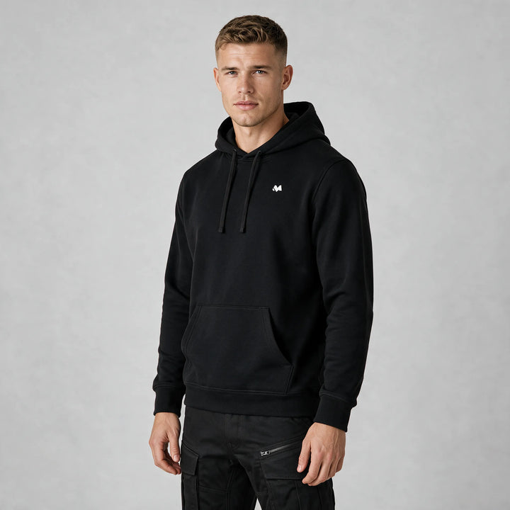 Front view of a man in a black hoodie with a small white MEXESS logo on the left chest