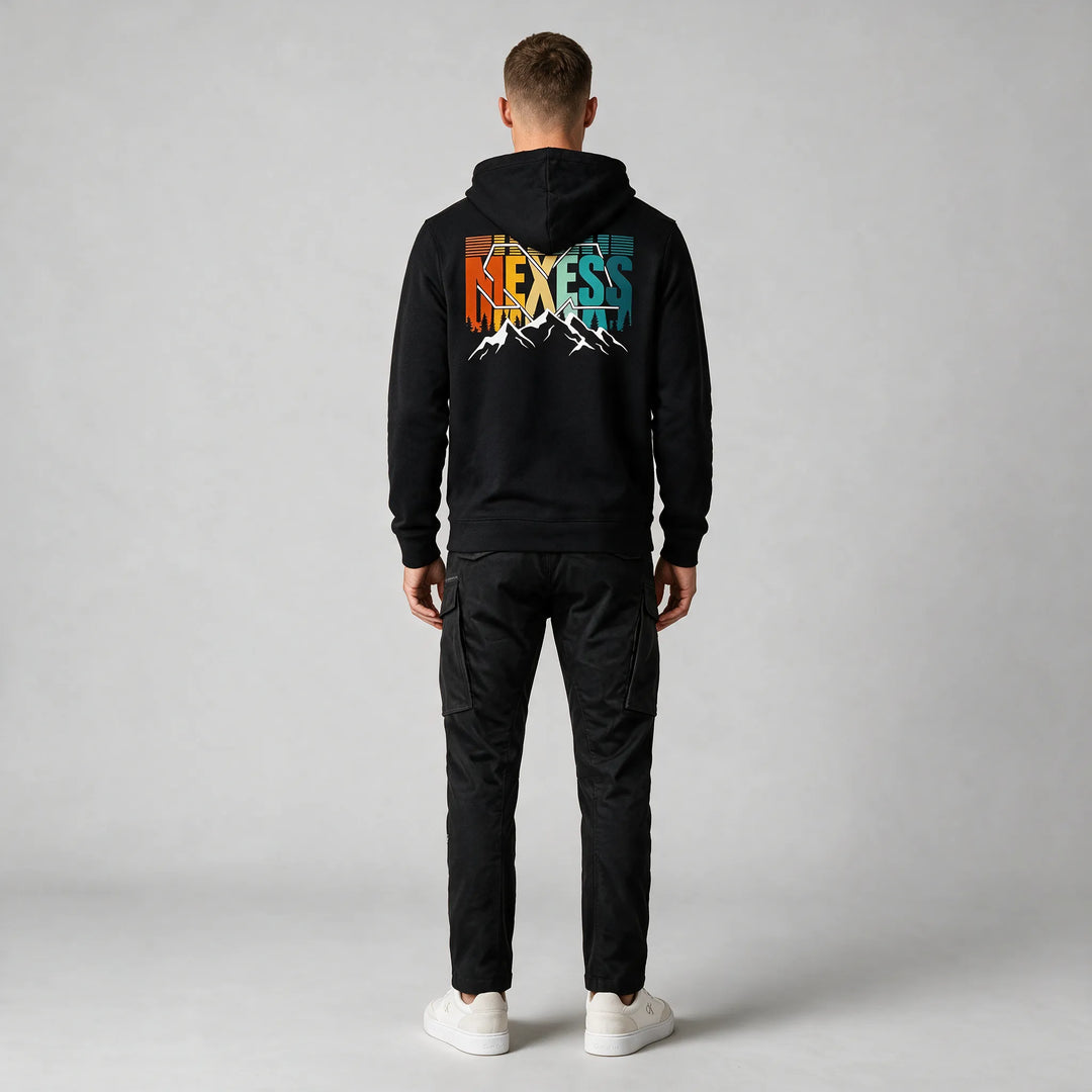 Full-length back view of a black mountain hoodie with a large multicolor MEXESS back print and black cargo pants