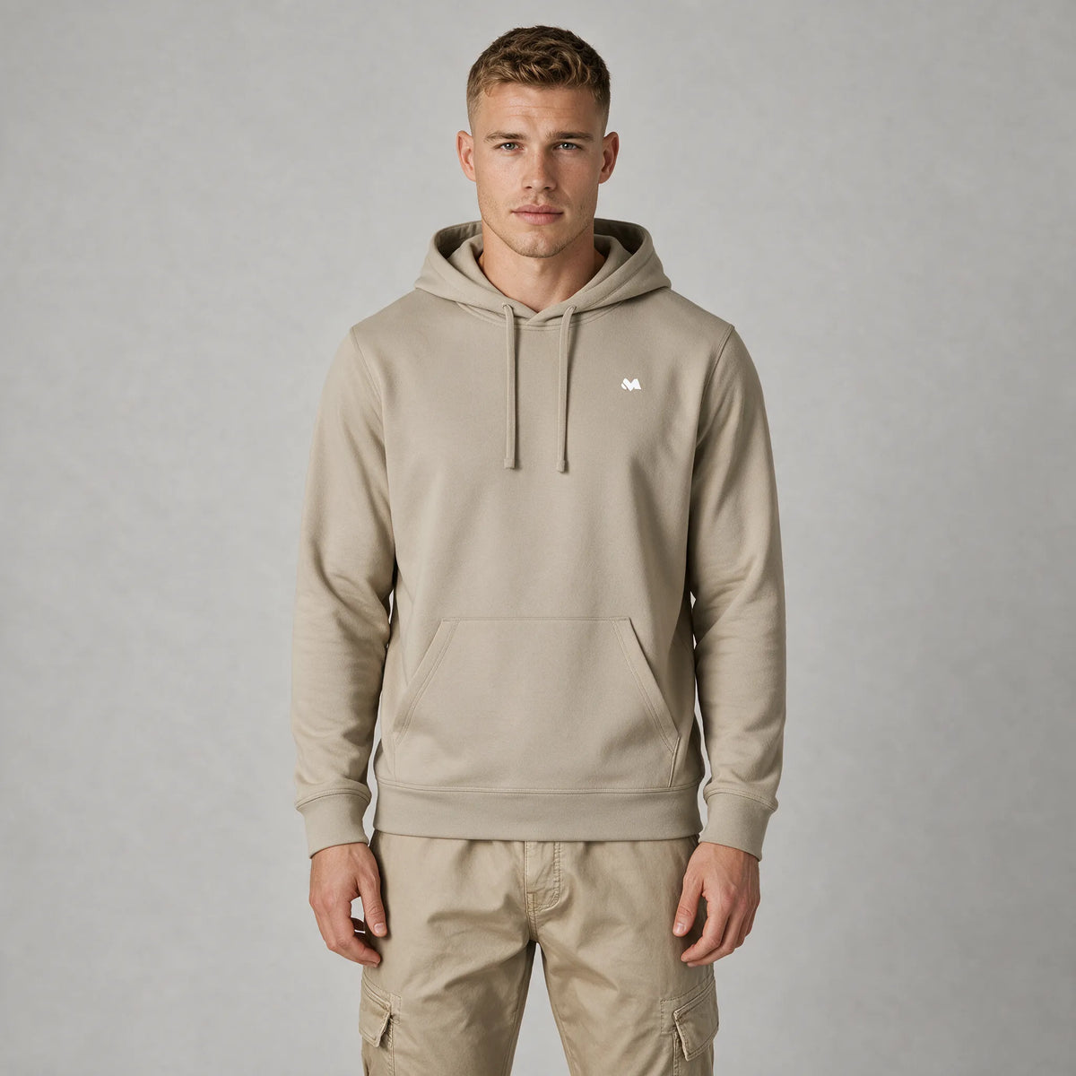 Front view of a man in a beige hoodie with a small white MEXESS logo on the left chest