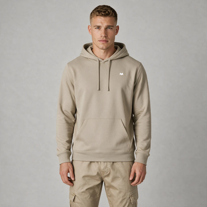 Front view of a man in a beige hoodie with a small white MEXESS logo on the left chest
