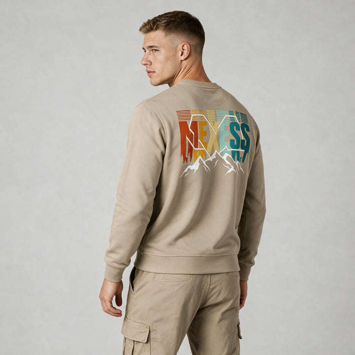 Beige organic cotton crewneck sweatshirt with a retro MEXESS mountain back print, worn by a man, rear three-quarter view