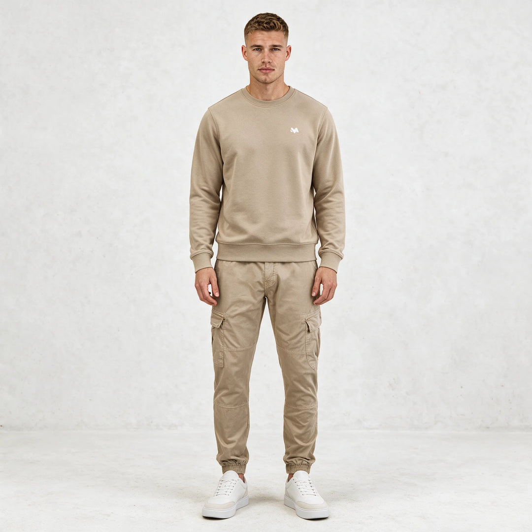 Full-length front view of a beige crewneck sweatshirt worn with beige cargo pants and white sneakers