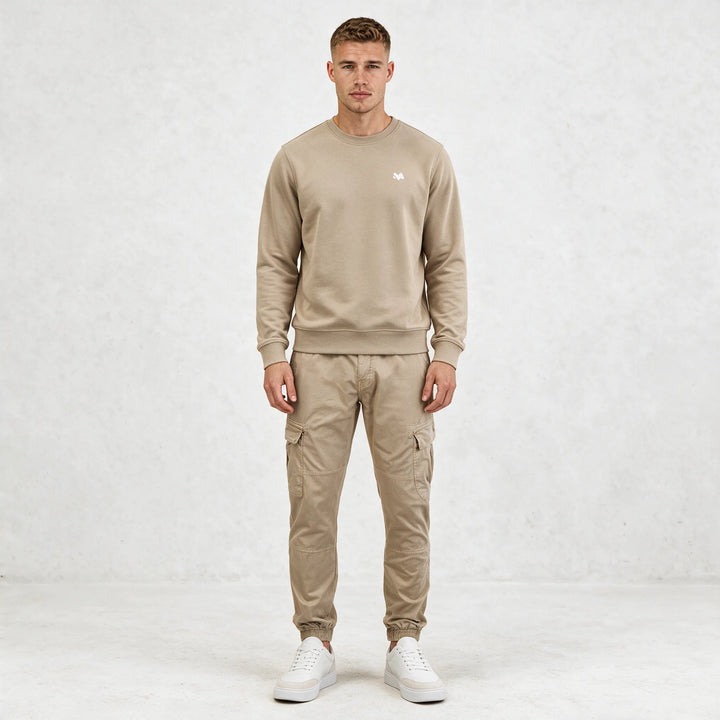Full-length front view of a beige crewneck sweatshirt worn with beige cargo pants and white sneakers