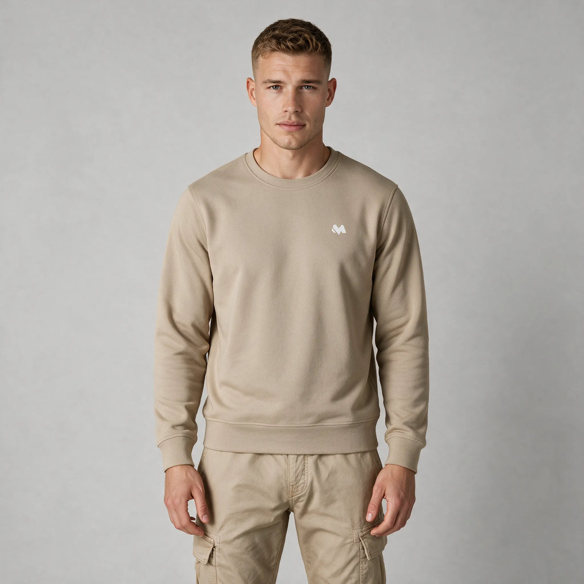 Front view of a man in a beige crewneck sweatshirt with a small white MEXESS logo on the left chest