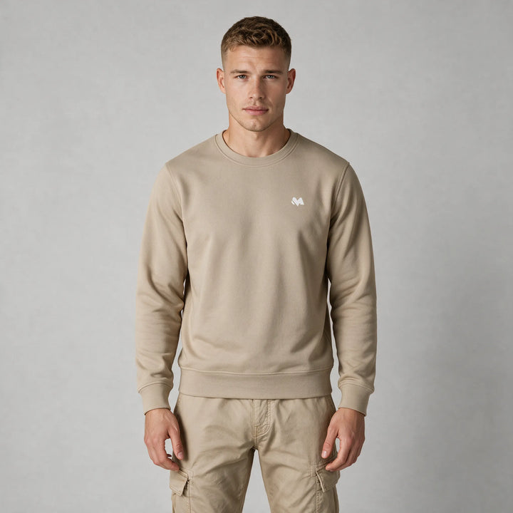 Front view of a man in a beige crewneck sweatshirt with a small white MEXESS logo on the left chest