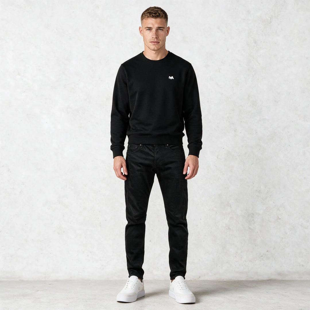 Full-length front view of a black crewneck sweatshirt worn with black cargo pants and white sneakers