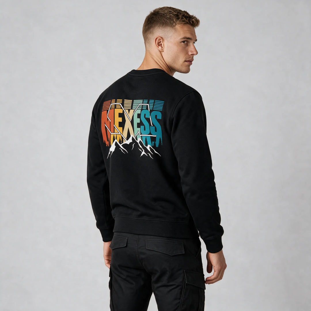 Black organic cotton sweatshirt with a colorful retro MEXESS mountain and pine tree back print, rear three-quarter view
