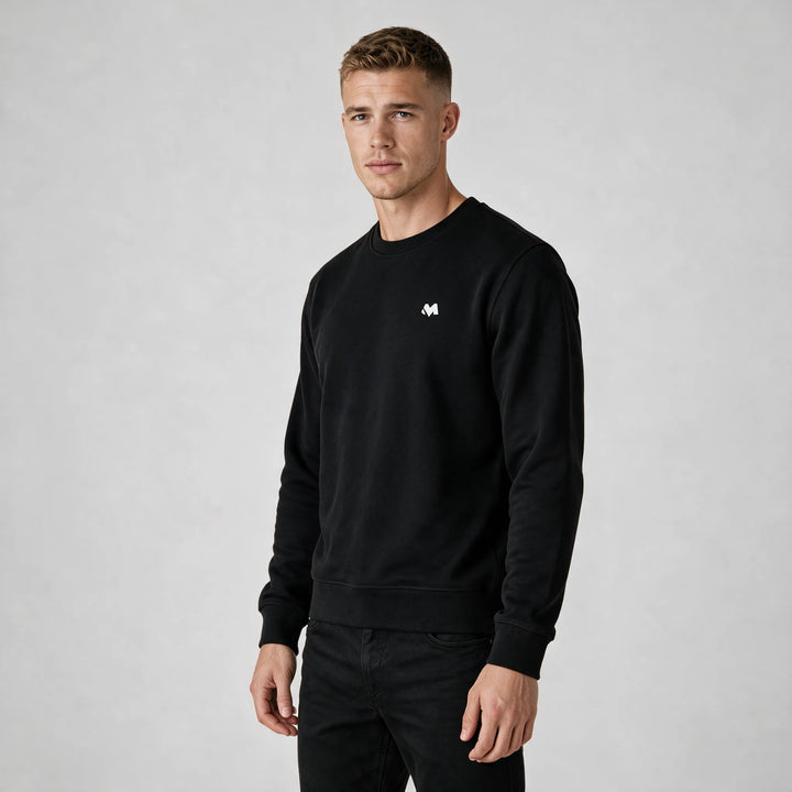 Front view of a man in a black crewneck sweatshirt with a small white MEXESS logo on the left chest