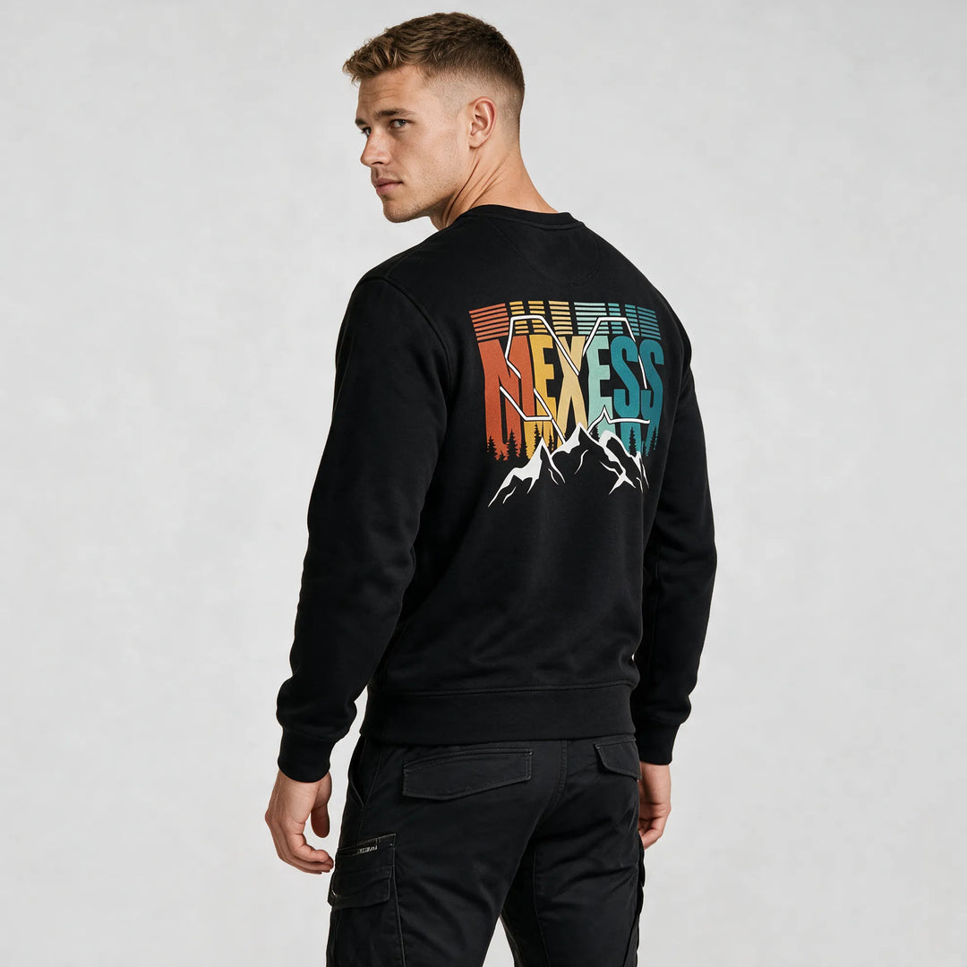 Man in a black graphic crewneck sweatshirt, back view of the MEXESS lettering in orange, yellow, mint and teal