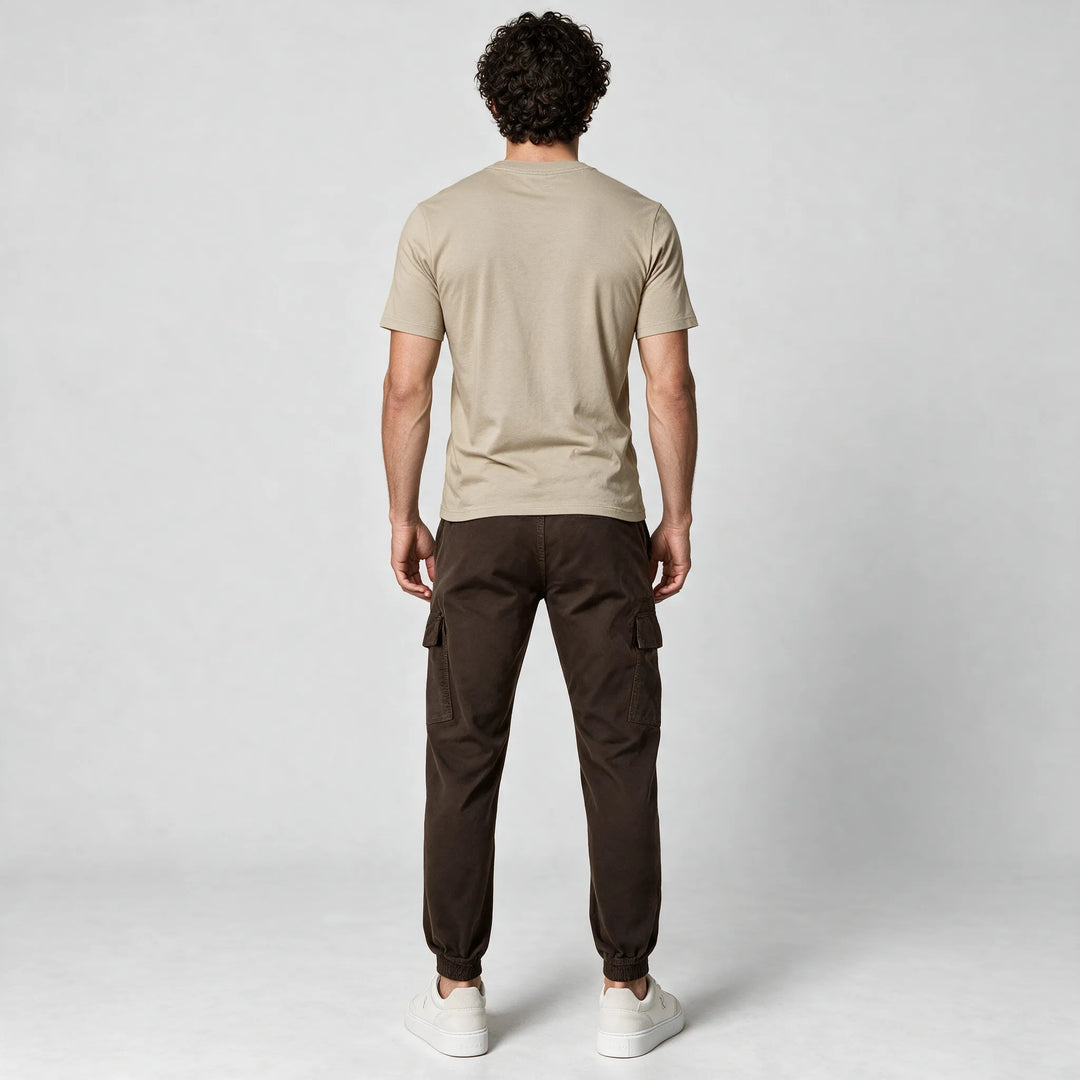 Full-length back view of a beige t-shirt worn with dark brown cargo pants and white sneakers