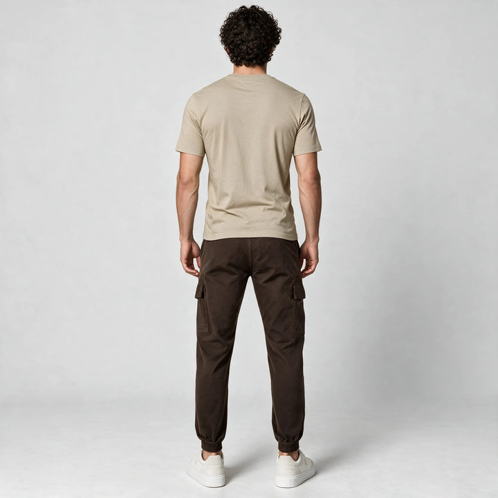 Full-length back view of a beige t-shirt worn with dark brown cargo pants and white sneakers