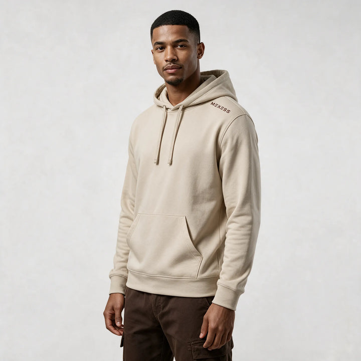 Front view of the beige organic cotton hoodie with a kangaroo pocket and a small MEXESS mark on the shoulder