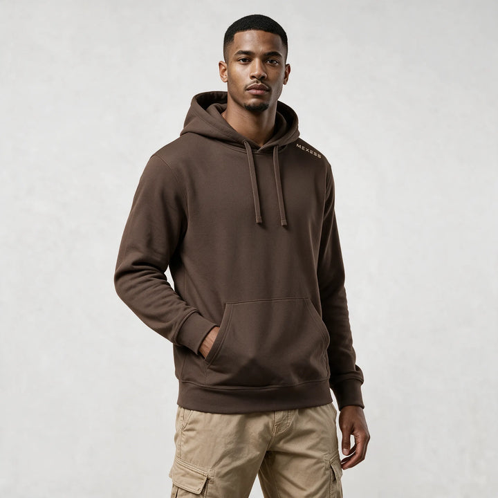 Front view of the mocha organic cotton hoodie with a hand in the kangaroo pocket