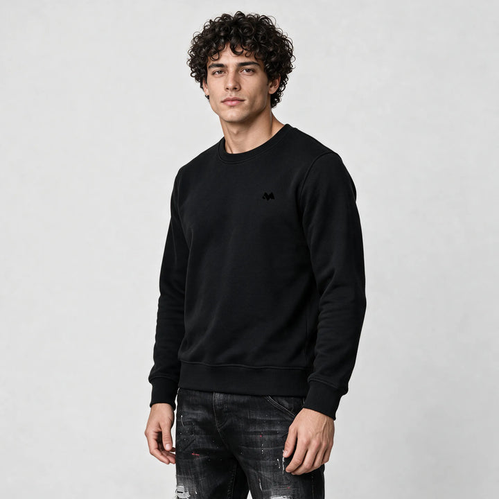 Front of the black crew neck sweatshirt with a small tonal M logo on the left chest