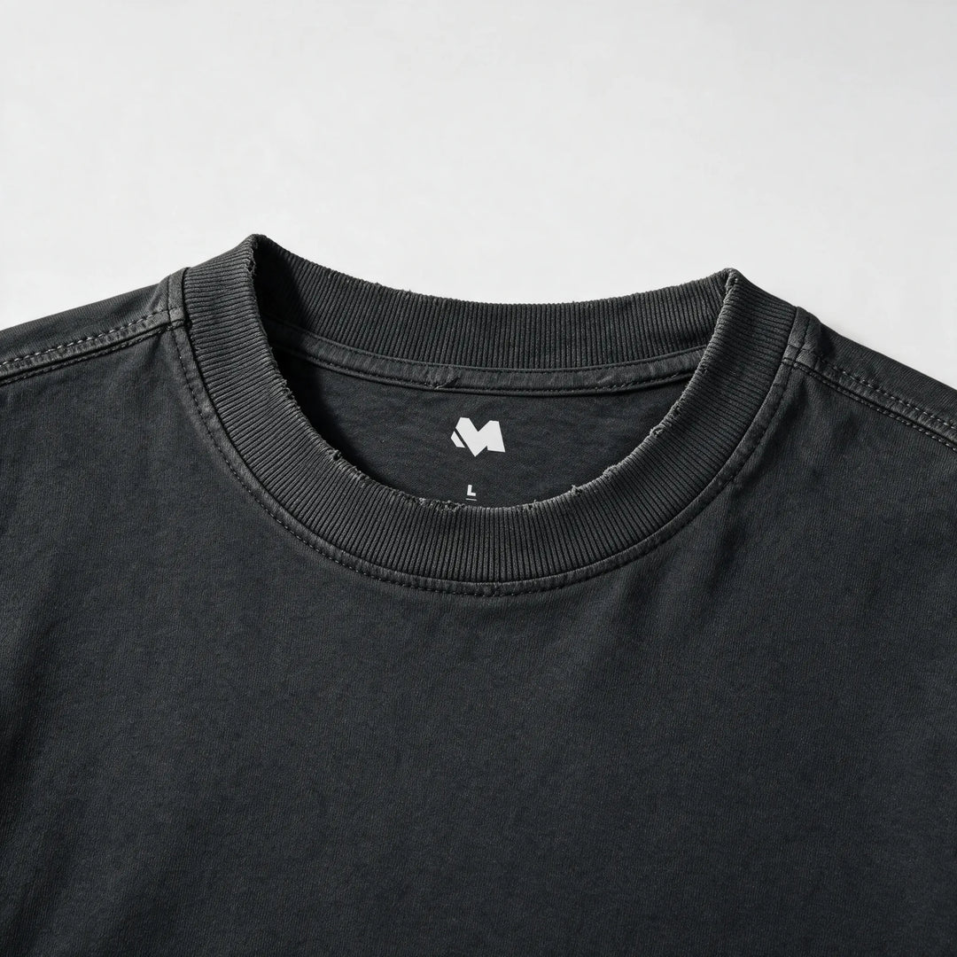Close-up of the ribbed crew neck and printed label of the washed black t-shirt