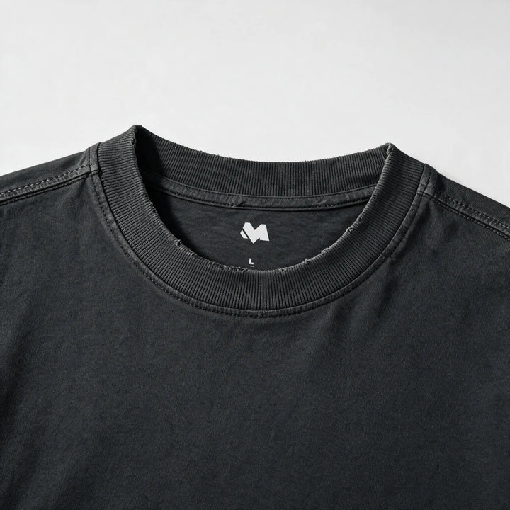 Close-up of the ribbed crew neck and printed label of the washed black t-shirt