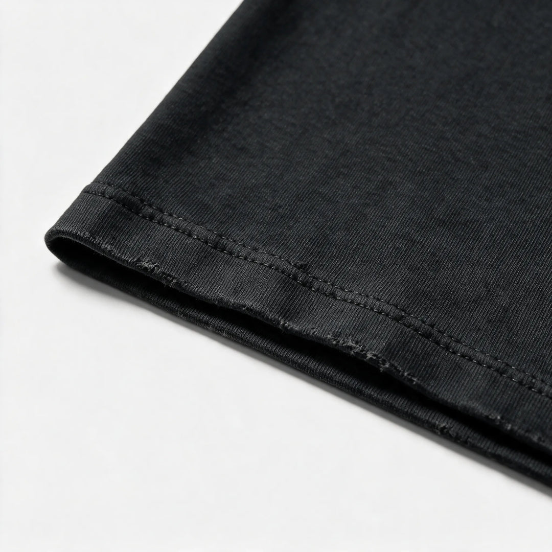 Close-up of the sleeve hem showing the garment dyed finish in washed black