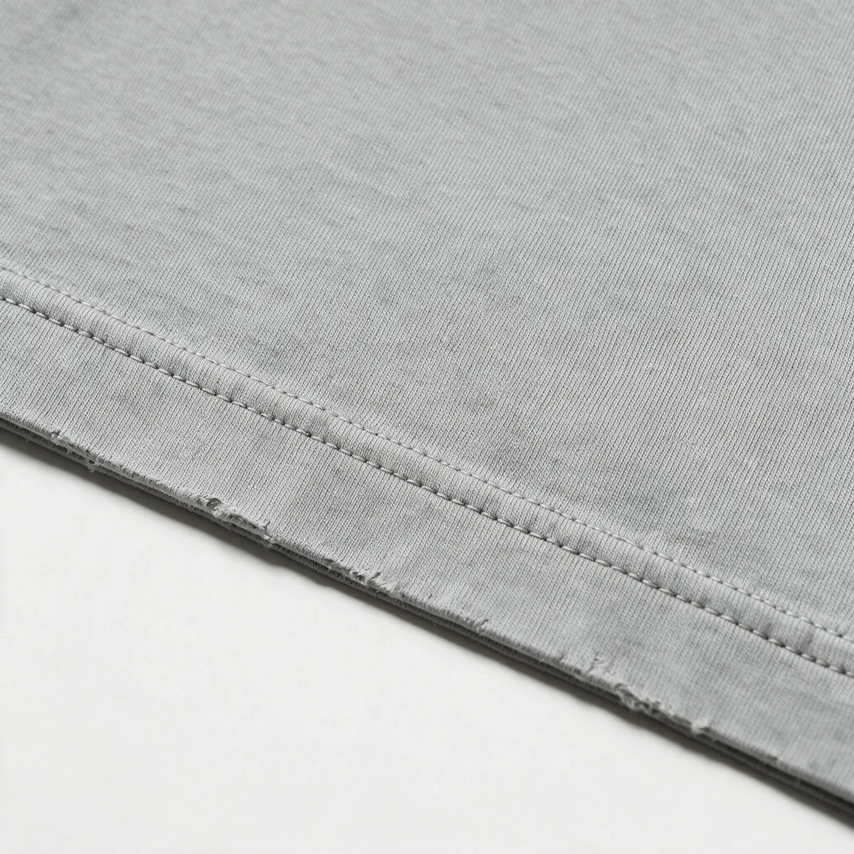 Close-up of the fabric and stitching of the gray garment dyed t-shirt