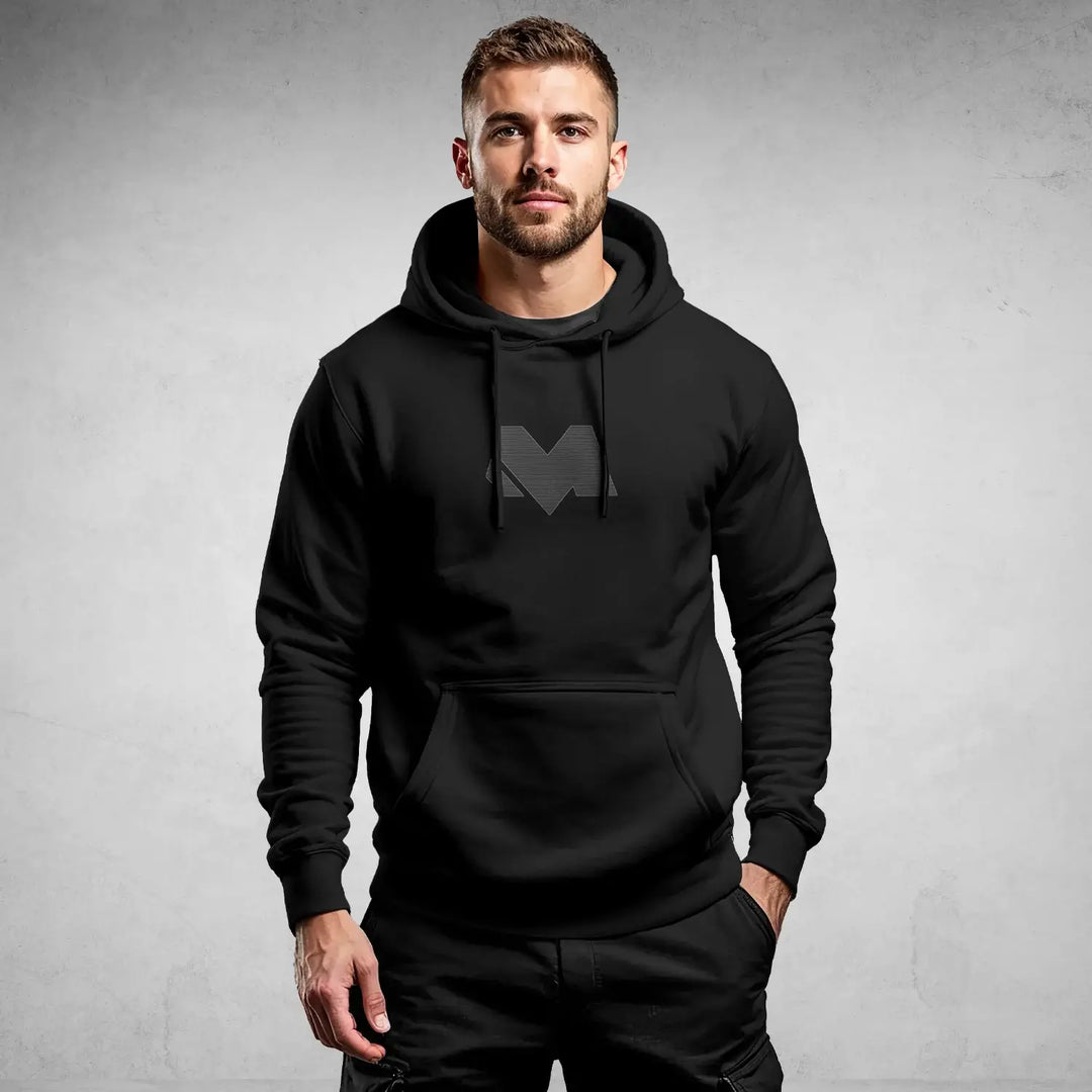 Model wearing iconic black streetwear hoodie DR697 with minimal logo, showcasing urban and modern style by MEXESS.